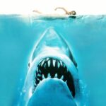 Affiche originale du film Jaws (1975) montrant un grand requin blanc émergeant vers une nageuse à la surface.