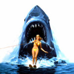 Illustration officielle de l'affiche de Jaws 2 (1978) montrant une skieuse nautique en bikini jaune fuyant un grand requin blanc géant qui surgit derrière elle.